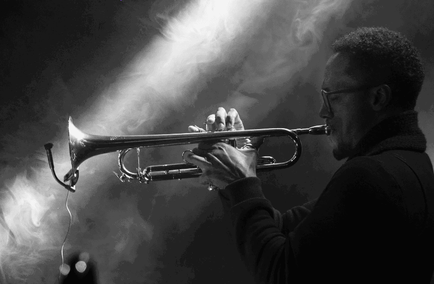 Un joueur de genre musical jazz jouant de la trompette dans une salle enfumée.