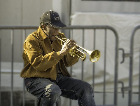 Homme en pleine technique d'improvisation à la trompette dans la rue