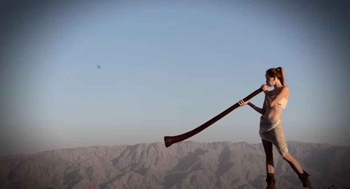 Femme soufflant dans un didgeridoo